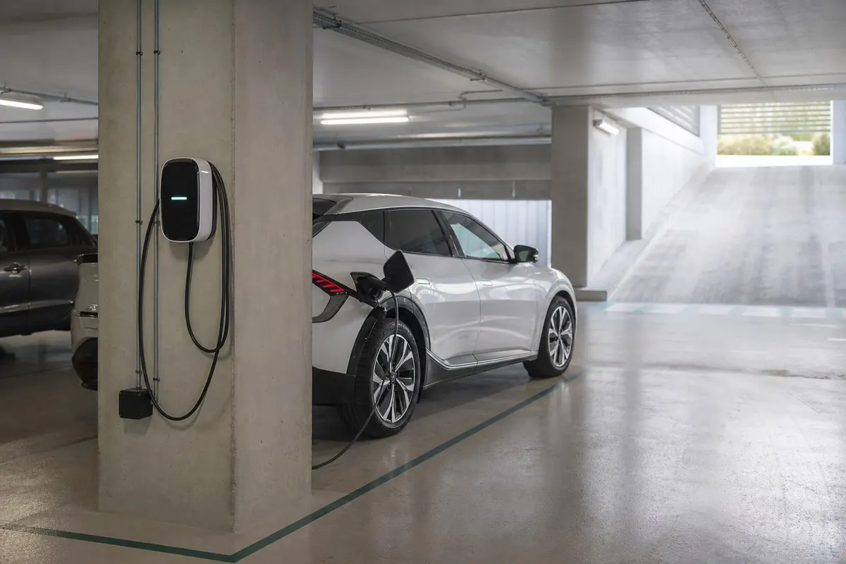 Borne de recharge installée dans un parking souterrain de copropriété avec voiture électrique